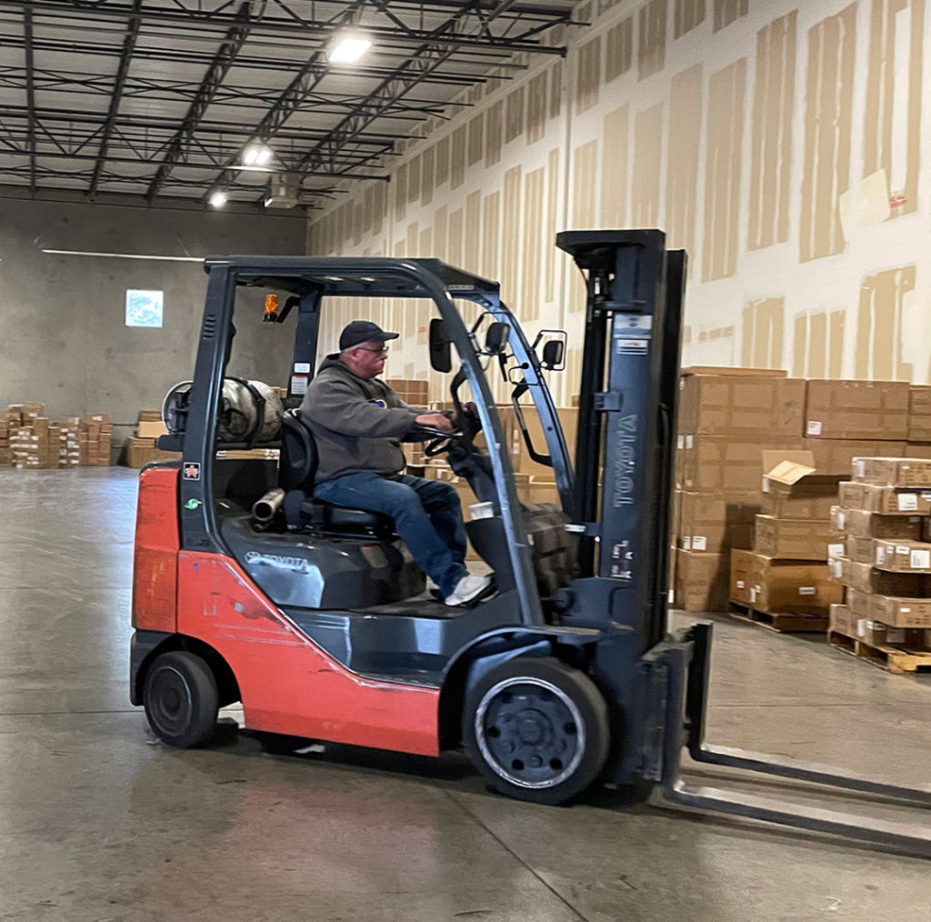 Man driving forklift in warehouse in Riverdale