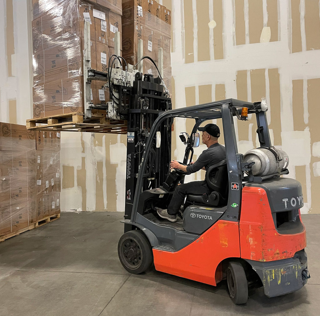 Forklift with pallets in background in Westbridge